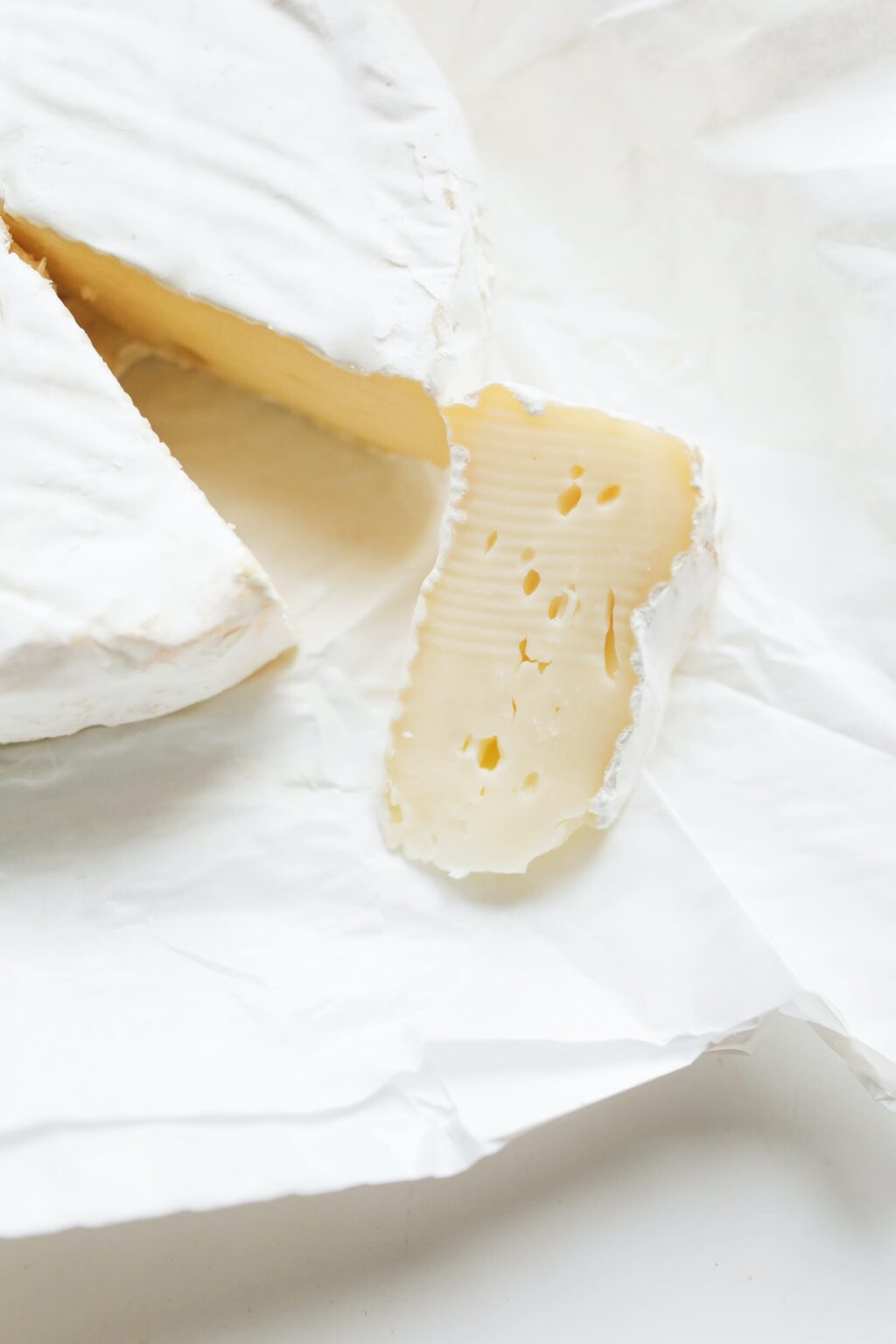prodotto: formaggio tipo brie tagliato su sfondo bianco