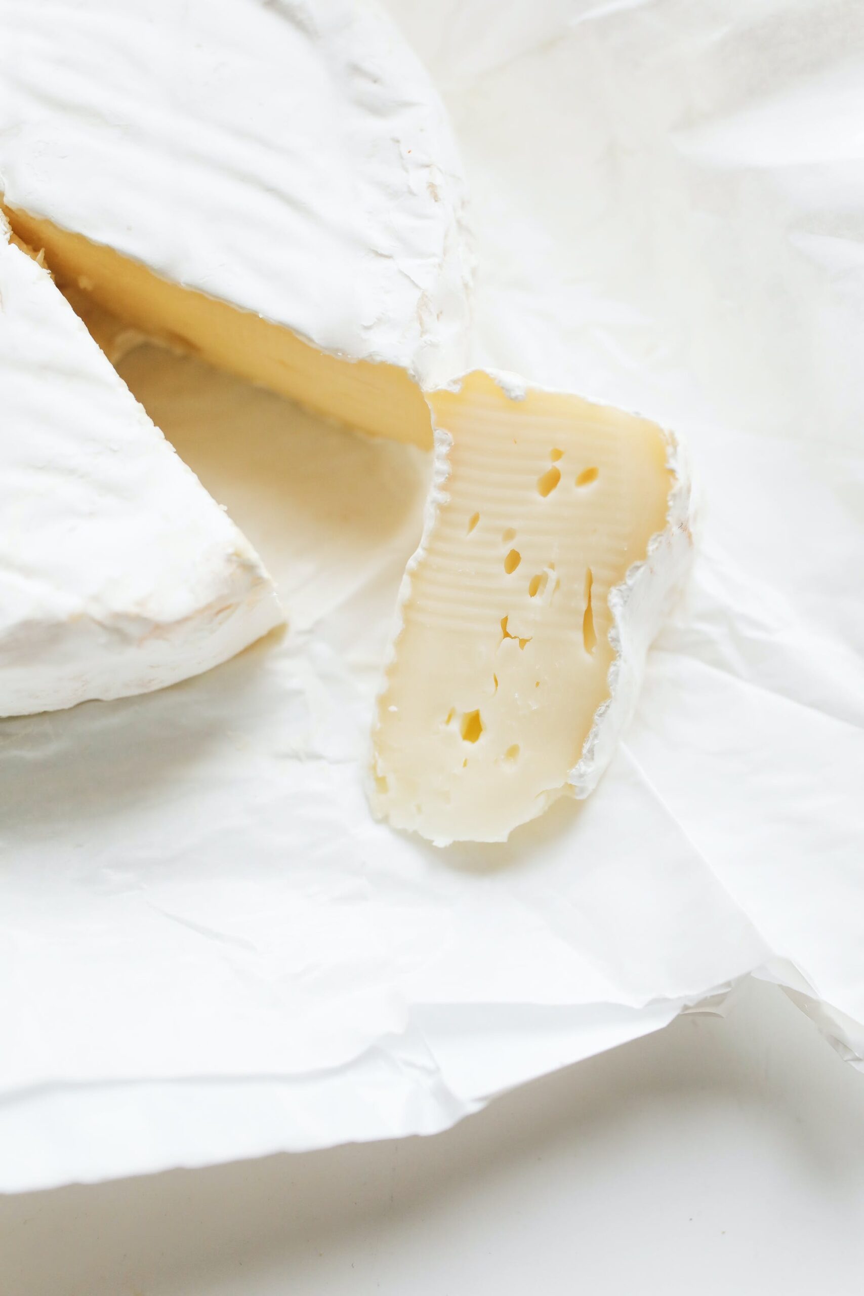 prodotto: formaggio tipo brie tagliato su sfondo bianco